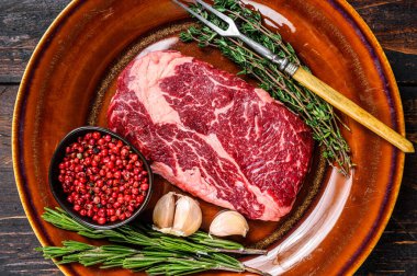 Kırsal bir tabakta siyah angus bifteği. Koyu ahşap arka plan. Üst görünüm