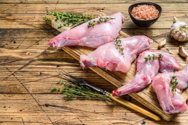 Kesme tahtasında çiğ tavşan bacağı. Ahşap arka plan. Üst Manzara. Boşluğu kopyala