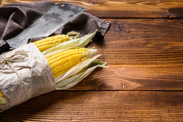 Kırsal ahşap masadaki koçanlarda taze mısır. Karanlık arka plan. Üst Manzara. Boşluğu kopyala