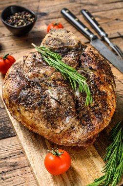 Kesme tahtasında kızarmış domuz jambonu. Saplanmış et. Ahşap arka plan. Üst görünüm