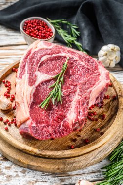 Kemiğe pirzola ya da kovboy bifteği. Çiğ Dallas bifteği. Beyaz ahşap arka plan. Üst görünüm