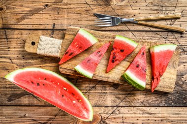 Bir yığın taze kırmızı dilimlenmiş karpuz. Ahşap arka plan. Üst görünüm