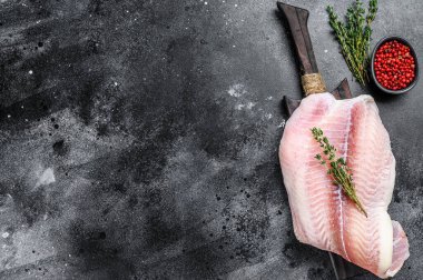 Kesme tahtasındaki çiğ balık filetosu. Siyah arka plan. Üst Manzara. Boşluğu kopyala