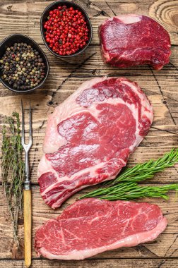 Taze çiğ siyah angus bifteği fileto Mignon, pirzola ya da kovboy, Striploin. Ahşap arka plan. Üst görünüm