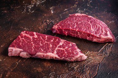 Çiğ Denver bifteği, mermer et. Karanlık arka plan. Üst görünüm