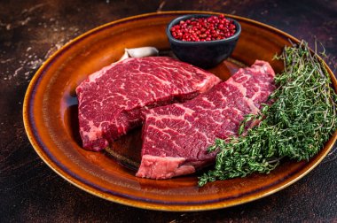 Taze çiğ Denver ya da kekik kaplı bir et parçası. Karanlık arka plan. Üst görünüm