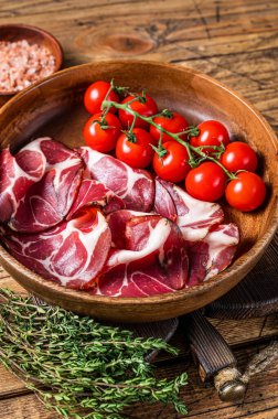İtalyan dilimlenmiş baharatlı koppa jambonu. Ahşap arka plan. Üst görünüm