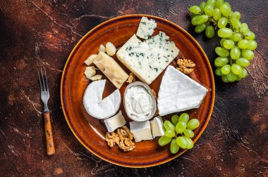Peynirli, peynirli, peynirli, rokforlu, mavi krem peynirli, üzümlü ve fındıklı. Karanlık arka plan. Üst görünüm
