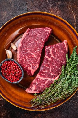 Taze çiğ Denver ya da kekik kaplı bir et parçası. Karanlık arka plan. Üst görünüm