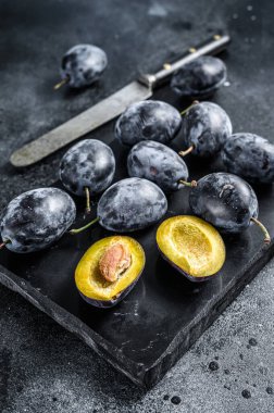 Bahçe erikleri taş masada. Siyah arka plan. Üst görünüm
