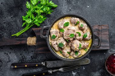 Kızartma tavasında krema soslu köfte. Siyah arka plan. Üst görünüm