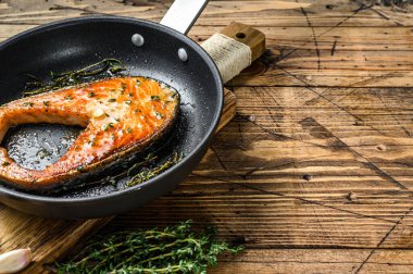 Tavada ızgara somon bifteği. Ahşap arka plan. Üst Manzara. Boşluğu kopyala