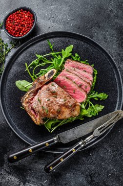 Az pişmiş ızgara biftekli biftek. Siyah arka plan. Üst görünüm