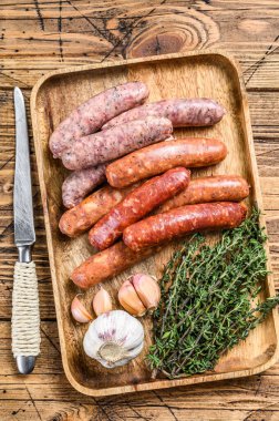 Çiğ sosis varyasyonu, sığır eti ve domuz eti. Ahşap arka plan. Üst görünüm