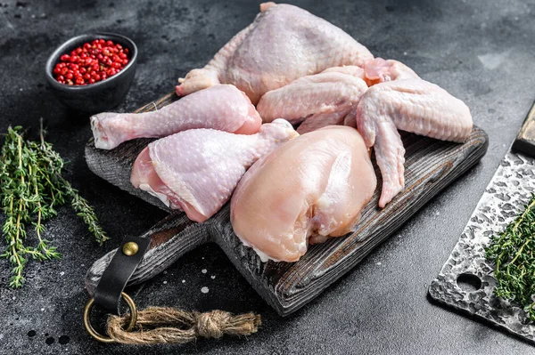 Porções de frango cru para cozinhar e churrasco com seios sem pele, baqueta e asas. Fundo preto. Vista superior — Fotografia de Stock