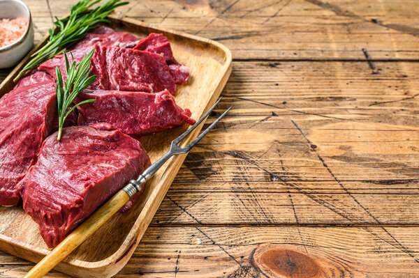 Pieces of Raw liver offal in a tray. wooden background. Top view. Copy space