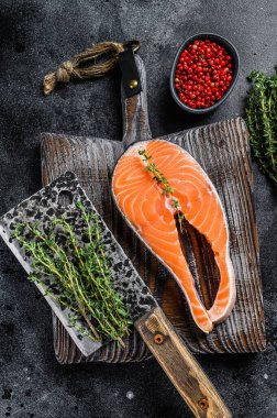 Biberli biftek şeklinde dilimlenmemiş somon balığı. Siyah arka plan. Üst görünüm