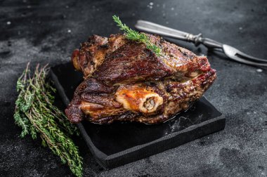 Fırında kuzu kuzu kuzu budu ve kekik. Siyah arka plan. Üst görünüm