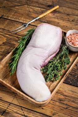 Et bıçağıyla kasap tepsisinde çiğ domuz dili. Ahşap arka plan. Üst görünüm