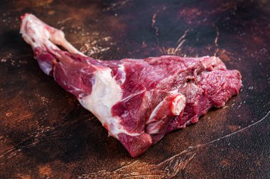 Kemikteki çiğ keçi eti. Karanlık arka plan. Üst görünüm