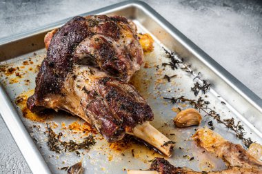 Kızarmış kuzu butun bacağı fırın tabağında. Beyaz arka plan. Üst görünüm