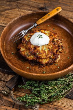 Kızarmış patates gözlemesi ya da ahşap tabakta otlu börek. Ahşap arka plan. Üst görünüm