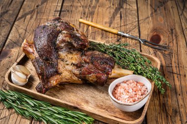 Ahşap bir tepside kızarmış keçi budu eti. Ahşap arka plan. Üst görünüm