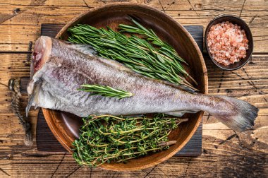 Çiğ morina ya da ahşap tabakta otlu morina balığı. Ahşap arka plan. Üst görünüm