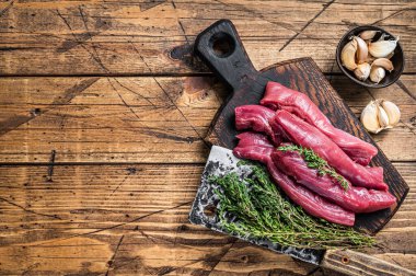 Et satırıyla kasap panosunda çiğ kuzu fileto fileto. Ahşap arka plan. Üst Manzara. Boşluğu kopyala