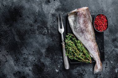 Pişmemiş çiğ morina balığı kekik ile mermer tahtada. Siyah arka plan. Üst Manzara. Boşluğu kopyala