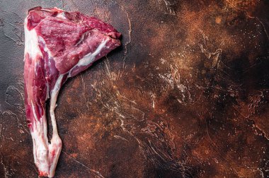 Kemikteki çiğ keçi eti. Karanlık arka plan. Üst Manzara. Boşluğu kopyala