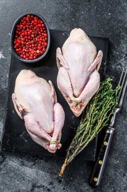 Çiftlik çevresi dostu çiğ bıldırcın pişirmeye hazır. Siyah arka plan. Üst görünüm