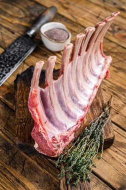 Kesme tahtasındaki çiğ kuzu kaburga askısı. Ahşap arka plan. Üst görünüm