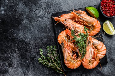 Kırmızı Langostino karidesleri mermer bir tahtanın üzerinde. Siyah arka plan. Üst Manzara. Boşluğu kopyala