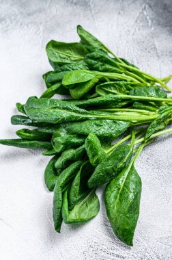 Taş bir masada çiğ ıspanak yaprakları. Beyaz arka plan. Üst görünüm