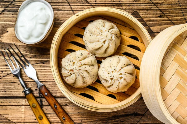 Albóndigas al vapor asiáticas Manti en un vapor de bambú. Fondo de madera. Vista superior — Foto de Stock