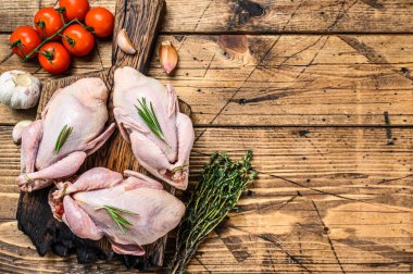 Kesme tahtasında çiğ bıldırcın. Ahşap arka plan. Üst Manzara. Boşluğu kopyala