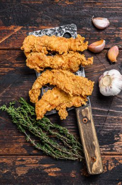 Kızarmış tavuk göğsü şeritleri. Karanlık ahşap arka plan. Üst görünüm