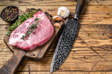 Kesme tahtasında bıçakla taze çiğ mermer et biftekleri. Ahşap arka plan. Üst Manzara. Boşluğu kopyala