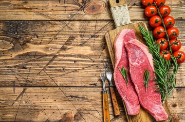 Çiğ sığır filetosu kasketi ya da doğrama tahtasında Picanha bifteği. Ahşap arka plan. Üst Manzara. Boşluğu kopyala
