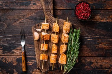 Ahşap tahtada ızgara somon balığı kebabı. Koyu ahşap arka plan. Üst Görünüm