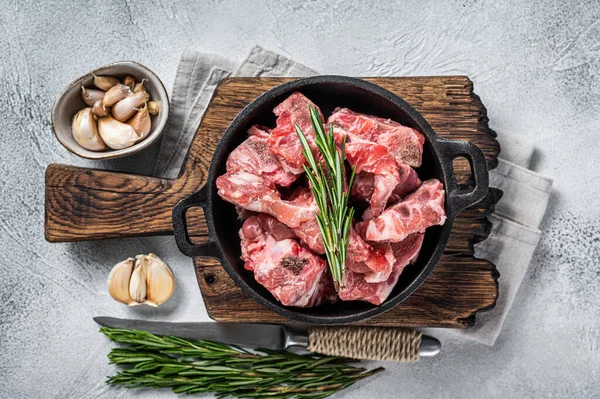 Raw diced meat cubes with bone in a pan. White background. Top View