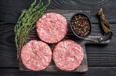 Çiğ tavuklu hindi köftesi, kıymalı pirzola. Siyah ahşap arka plan. Üst görünüm