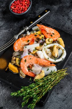 Karides, karides, midye, mürekkep balığı ve ahtapotla taze deniz ürünleri karışımı. Siyah arka plan. Üst görünüm