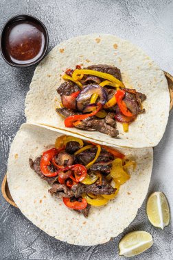 Et şeritli Fajitalar, renkli dolmalık biber ve soğan, tortilla ve salsa ile servis edilir. Beyaz arka plan. Üst görünüm