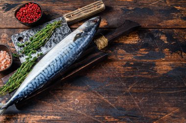 Taze çiğ balık uskumrusu bir satırla tahta bir kesme tahtasının üzerinde. Koyu ahşap arka plan. Üst Manzara. Boşluğu kopyala