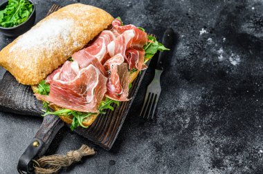 Ciabatta ekmeğinde Iberico Jamon jambonlu sandviç. Siyah arka plan. Üst Manzara. Boşluğu kopyala