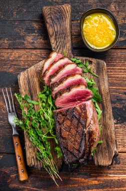 Dilimlenmiş ördek eti göğüs bifteği. Koyu ahşap arka plan. Üst görünüm