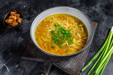 Masada erişteli taze ev yapımı tavuk çorbası. Siyah arka plan. Üst görünüm