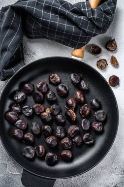 Tahta bir masada tavada kestane kızart. Beyaz arka plan. Üst görünüm